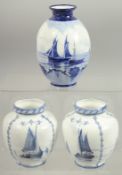 A ROYAL CROWN DERBY SET OF THREE VASES painted with sailing vessels by W.E.J. DEAN.