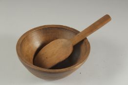 A TREEN CIRCULAR BUTTER BOWL AND SPOON. 8ins diameter.