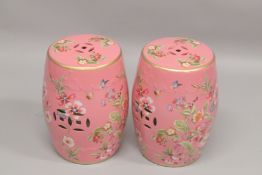 A PAIR OF CHINESE PINK GROUND POTTERY BARREL SEATS. 1ft 6ins high.