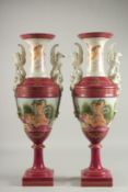 A TALL PAIR OF TAPERING SEVRES DESIGN TWO HANDLED VASES with classical scenes. 24ins high.