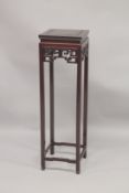 A CHINESE REDWOOD STAND with square top, pierced frieze, on stretchered square legs. 3ft 8.5ins high