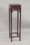 A CHINESE REDWOOD STAND with square top, pierced frieze, on stretchered square legs. 3ft 11ins high