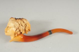 A MEERSCHAUM PIPE CARVED AS THE HEAD OF A LADY. Head, 5cm long, 6cm deeep with amber mouth piece.