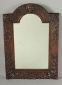 A GOOD 18TH CENTURY CARVED OAK ARCHED MIRROR carved with angels heads, shells and flowers. 23ins x
