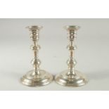 A PAIR OF SILVER CIRCULAR CANDLESTICKS on loaded bases. 6.5ins high. London.