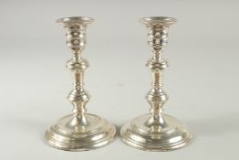A PAIR OF SILVER CIRCULAR CANDLESTICKS on loaded bases. 6.5ins high. London.