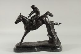 A BRONZE HORSE AND JOCKEY 'OVER THE STICKS' on a shaped marble base. 12ins high.