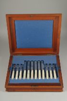 A SET OF 12 DESSERT KNIVES AND FORKS with mother of pearl handles in a mahogany canteen. Sheffield