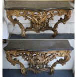 A SUPERB NEAR PAIR OF 18TH CENTURY CARVED AND GILDED CONSOLE TABLES OF SERPENTINE FORM, with