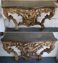 A SUPERB NEAR PAIR OF 18TH CENTURY CARVED AND GILDED CONSOLE TABLES OF SERPENTINE FORM, with
