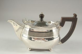 A GEORGE III SILVER TEA POT with wooden handle on four ball feet. London 1806. Maker J. W. WEIGHT