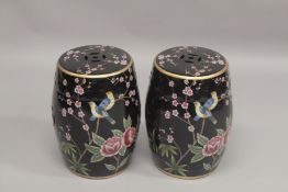 A PAIR OF CHINESE BLACK GROUND POTTERY BARREL SEATS. 1ft 6ins high.