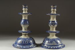 A PAIR OF BLUE AND WHITE CANDLESTICKS. 11ins high.