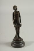 A STANDING BRONZE NUDE on a circular base. 7ins high.