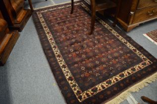 A Persian rug with stylised floral decoration 200cm x 110cm.