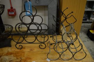 Three wrought iron wine bottle stands.