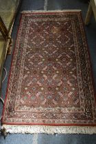 Persian rug, rust ground with all-over floral decoration 150cm x 90cm.