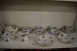 A 19th century child's porcelain tea set painted with butterflies and flowers.