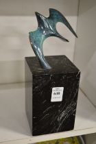 A stylish small bronze sculpture of a bird on a marble base.