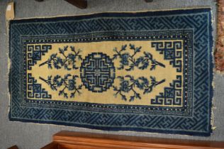 A small Chinese blue and cream rug 105cm x 58cm.