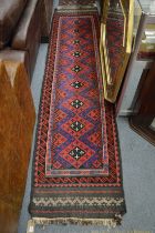 A Persian runner, red and blue ground with stylised cross shaped decoration 290cm x 68cm.