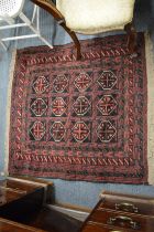 A small Persian rug with stylised geometric decoration 110cm x 106cm.