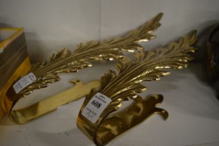 A pair of brass curtain tie backs.