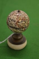 A bone miniature globe on stand.