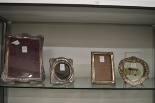 Four silver photograph frames.