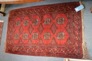 A small Bokhara rug, red ground with two rows of five medallions 125cm x 80cm.