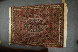 A good small Persian rug with all-over floral decoration 83cm x 63cm.