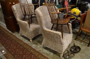 A pair of large wicker armchairs.