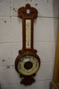 An oak cased barometer and thermometer.