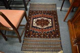 A good small Persian rug with central geometric motif and woven decoration to each end 140cm x