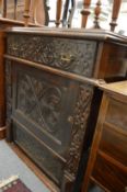 A carved oak cupboard with a frieze drawer above a cupboard door and a drop flap.