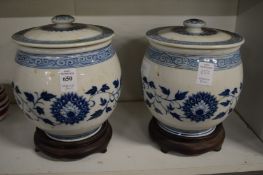A pair of Chinese blue and white jars, covers and stands (modern).