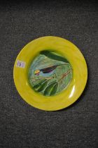 A pottery plate decorated with a bird on a branch.