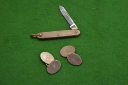 A pair of cufflinks and a miniature penknife.