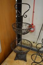 A wrought iron two tier fruit basket.
