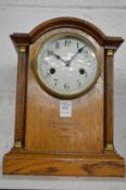 An Edwardian inlaid oak mantle clock.