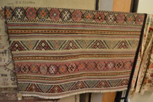 A woven tribal rug depicting bands of geometric decoration 135cm x 133cm.