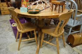 A pine circular table and three chairs.