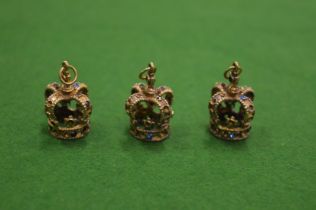 Three novelty pendants in the form of crowns.