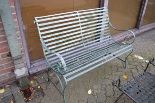 A wrought iron two seater garden bench.