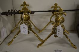 A pair of brass 'Victorian Jubilee' fire dogs and a wrought iron poker.