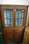 A mahogany standing corner cupboard with glazed upper section.
