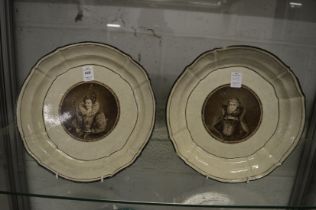 A pair of Continental moulded porcelain dishes, sepia tone decorated to the centre with a queen