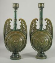 A PAIR OF 19TH CENTURY GREEN HISPANO-MORESQUE GLAZED CERAMIC CANDLESTICKS / VASES. 60cm high.