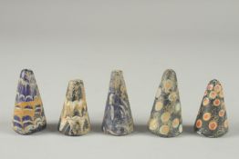 A COLLECTION OF FIVE RARE POSSIBLY EARLY ISLAMIC GLASS GAMING PIECES, each around 4.5cm high, (5).