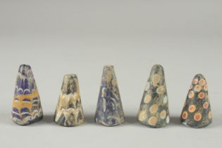 A COLLECTION OF FIVE RARE POSSIBLY EARLY ISLAMIC GLASS GAMING PIECES, each around 4.5cm high, (5).